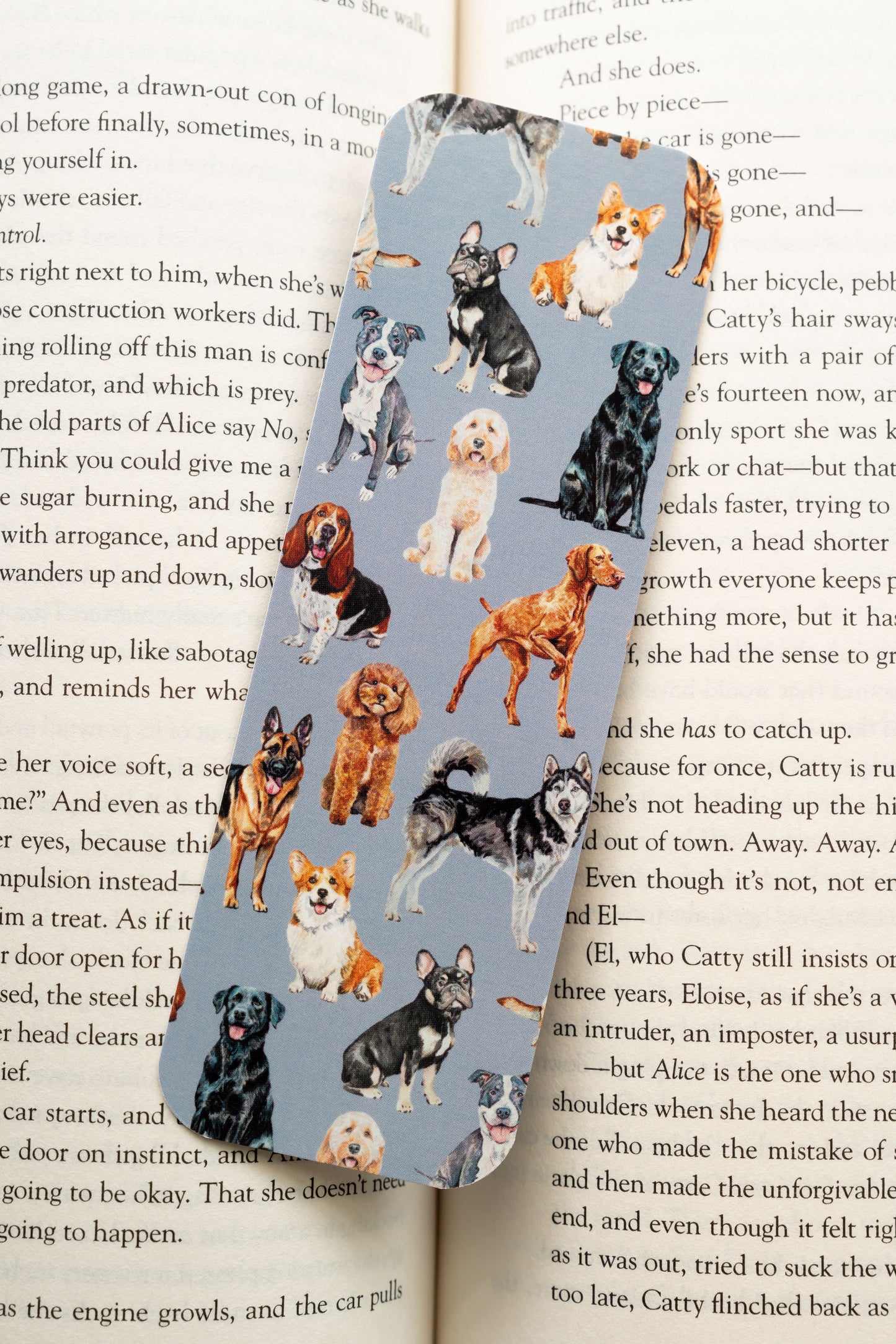 blue bookmark featuring images of various dogs on an open book