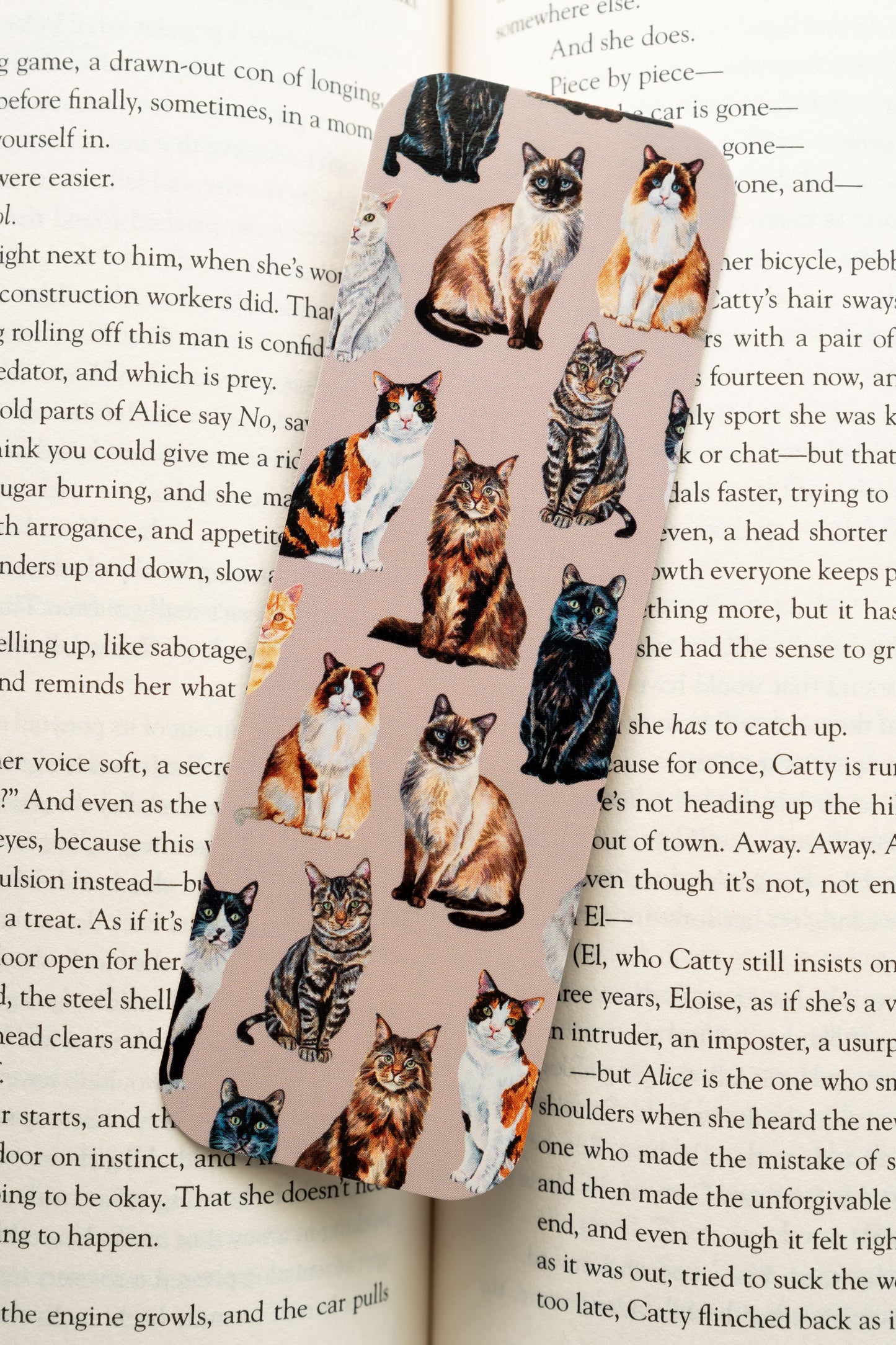bookmark with cat illustrations on a book page background