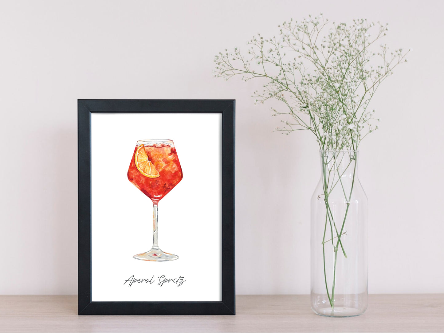 Watercolor art print of an aperol spritz drink in a black frame