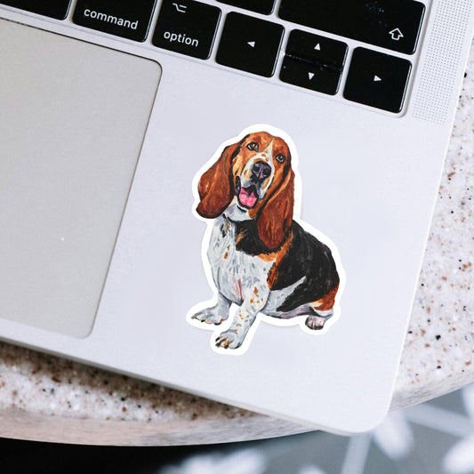 Laptop with a sticker of a Basset hound dog on the palm rest area
