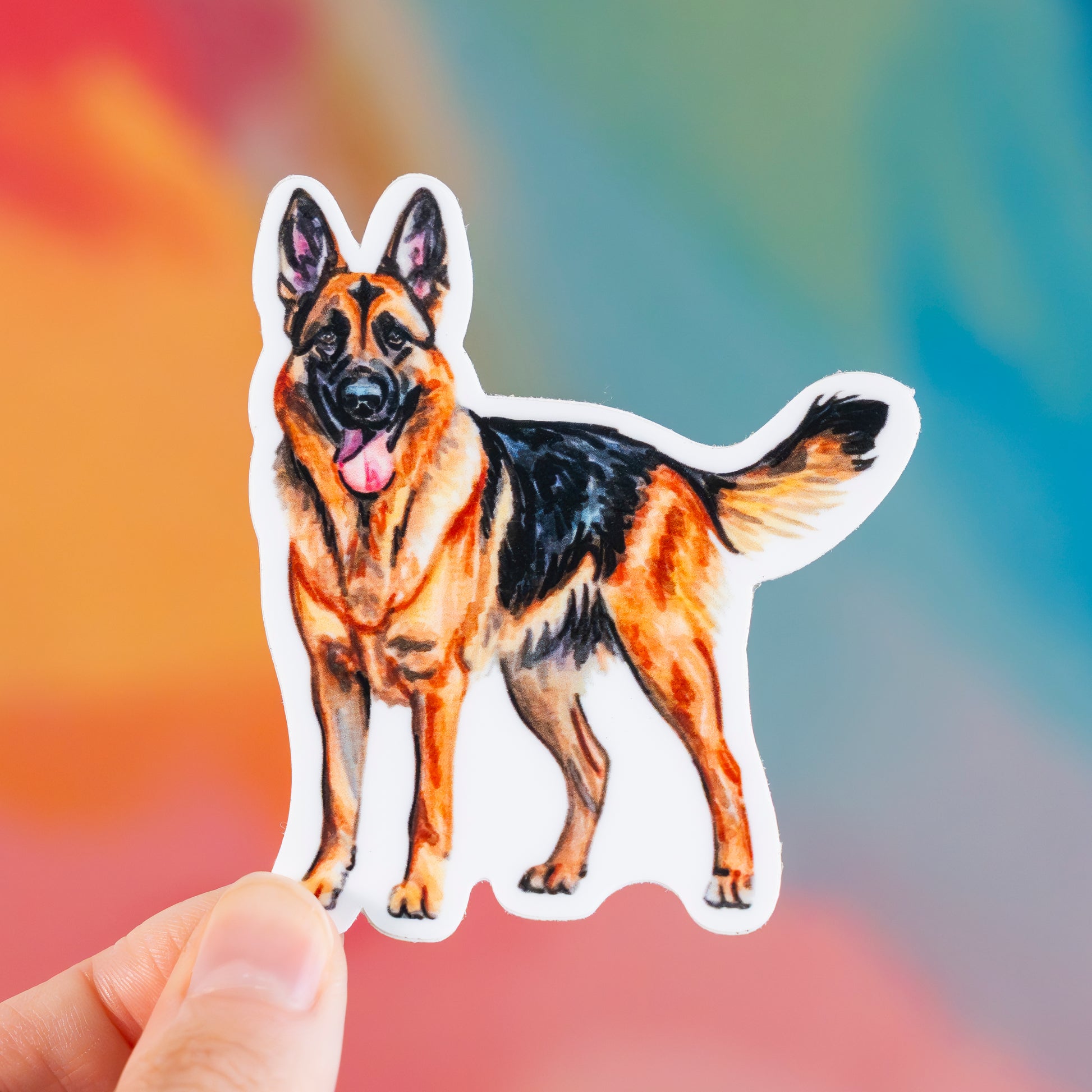 Sticker of a German Shepherd held against a colorful background