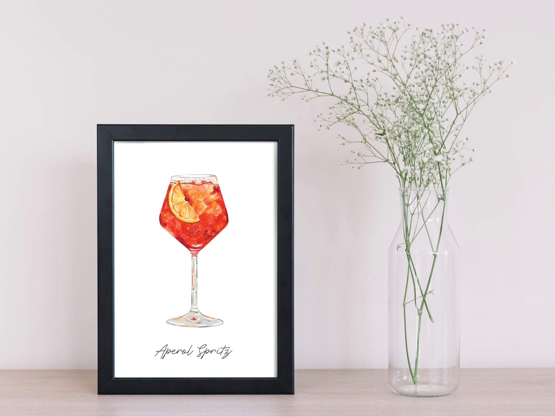 Watercolor art print of an aperol spritz drink in a black frame