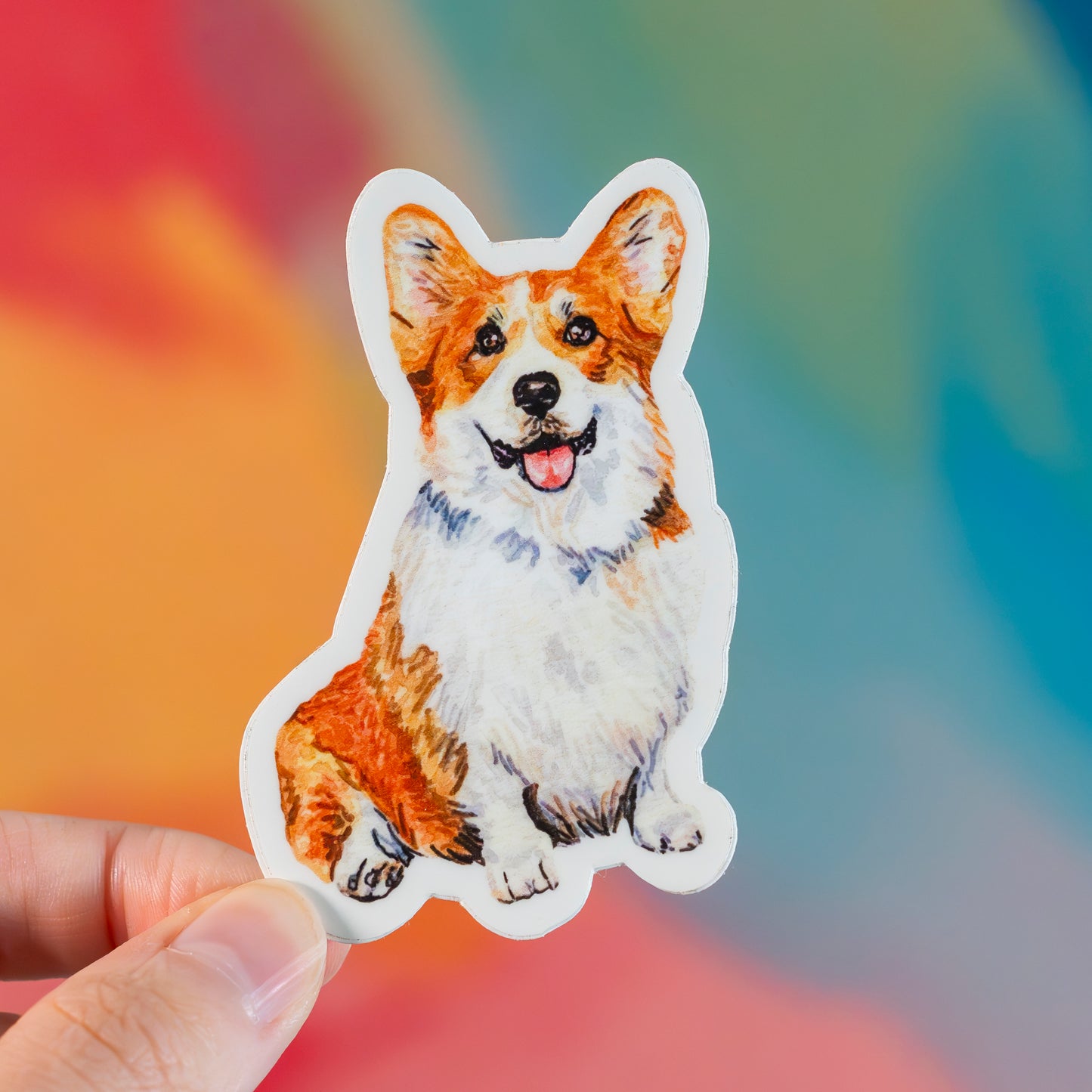 Sticker of a corgi dog held against a colorful blurred background