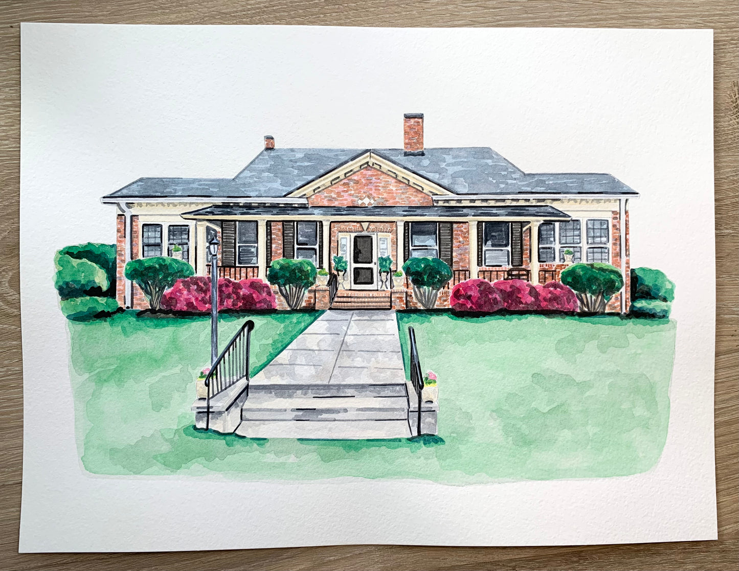 Watercolor painting of a house with a front lawn and pathway on a white background.