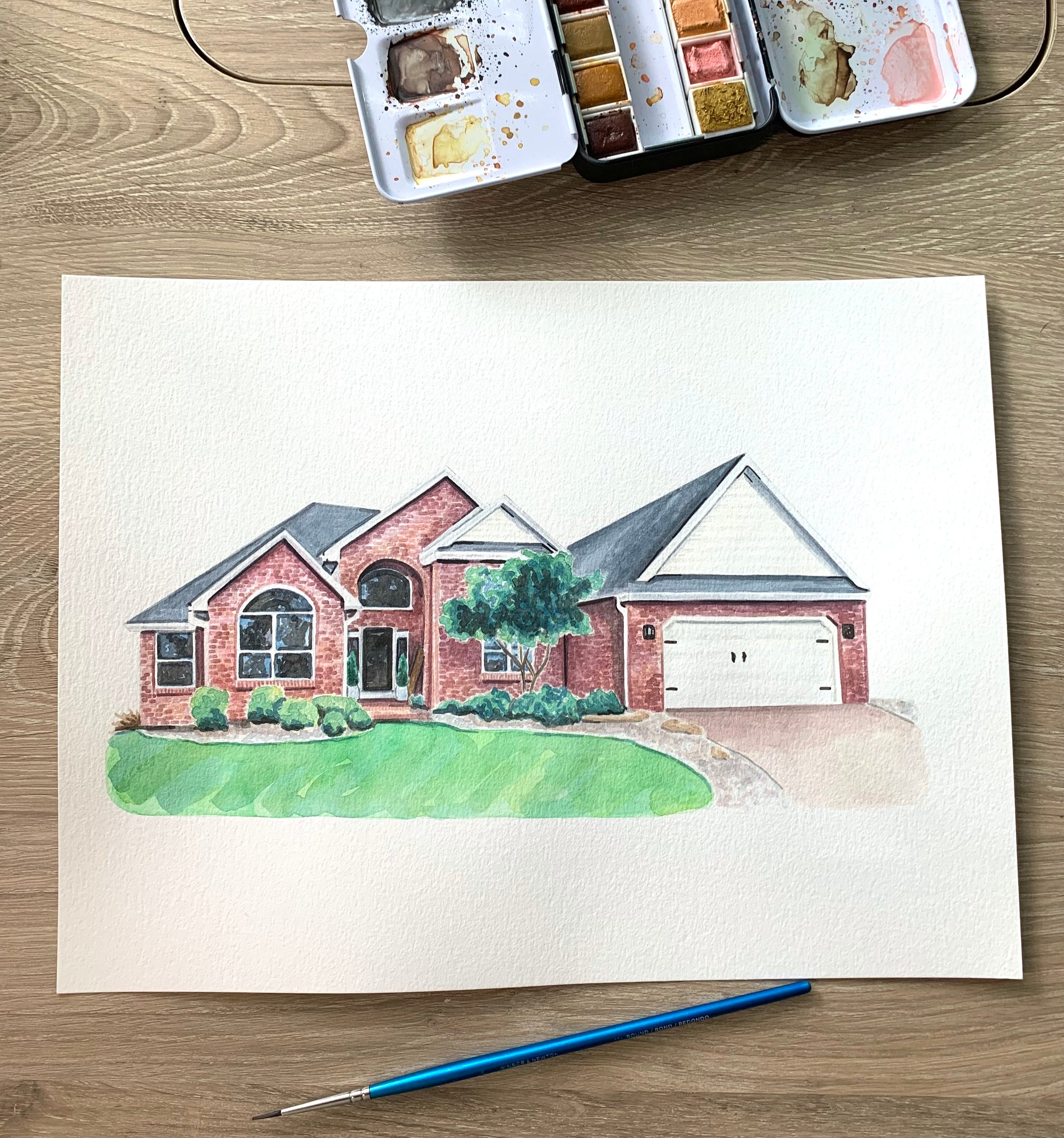 watercolor portrait of a brick house on a wooden surface