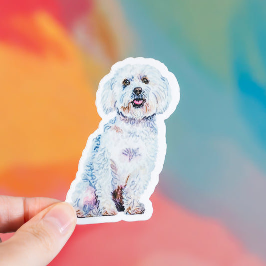 Sticker of a white dog held by a hand with a colorful blurred background
