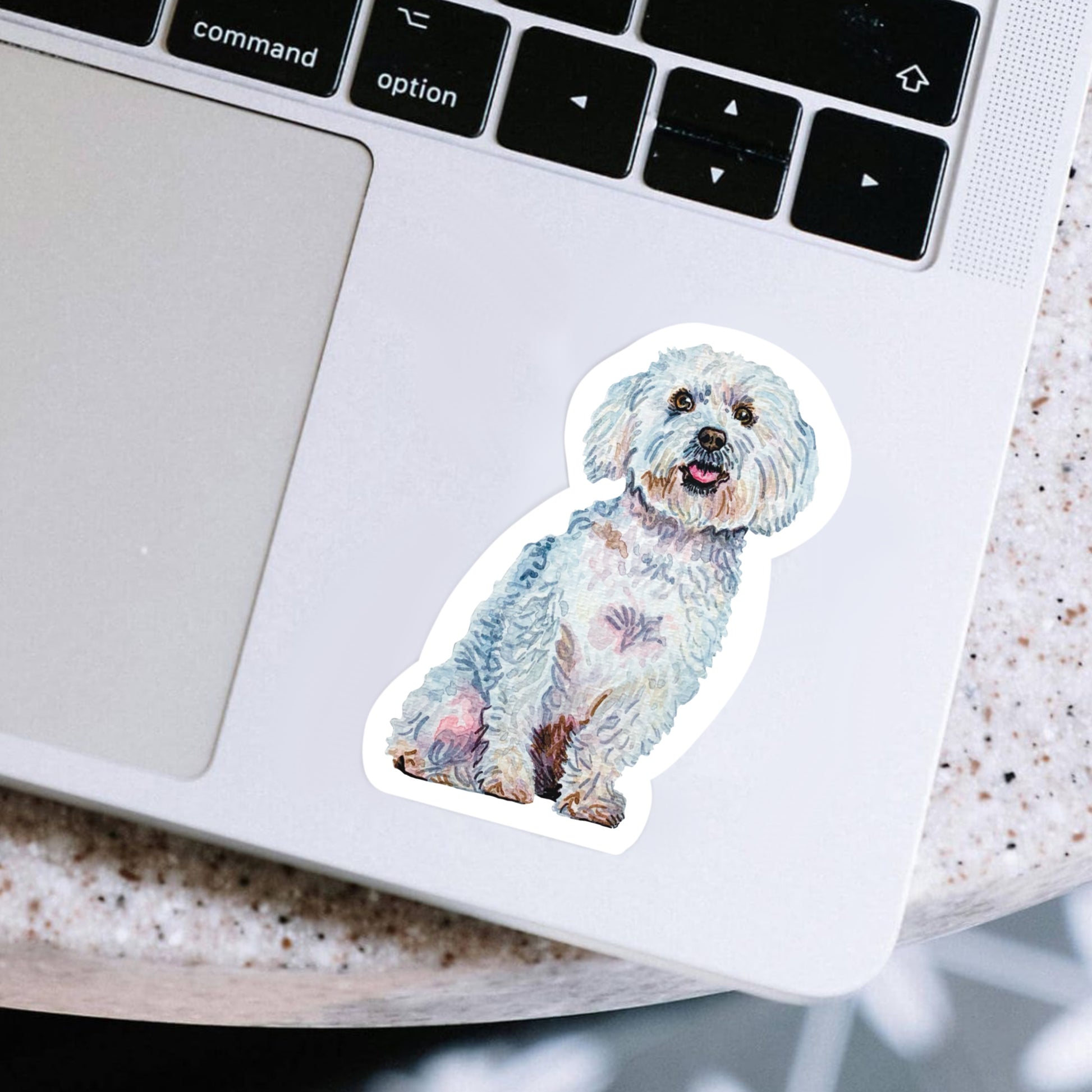 Laptop with a Maltese dog sticker on the palm rest area