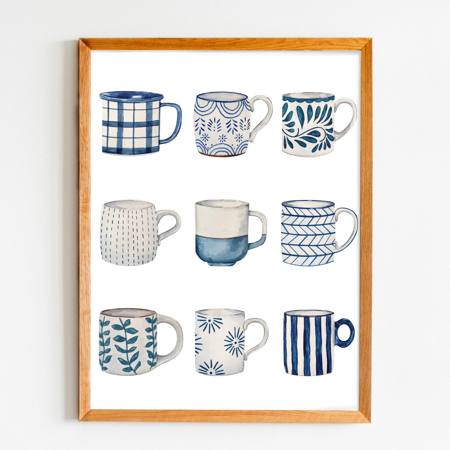 Framed artwork of nine blue and white mugs with various patterns on a white background